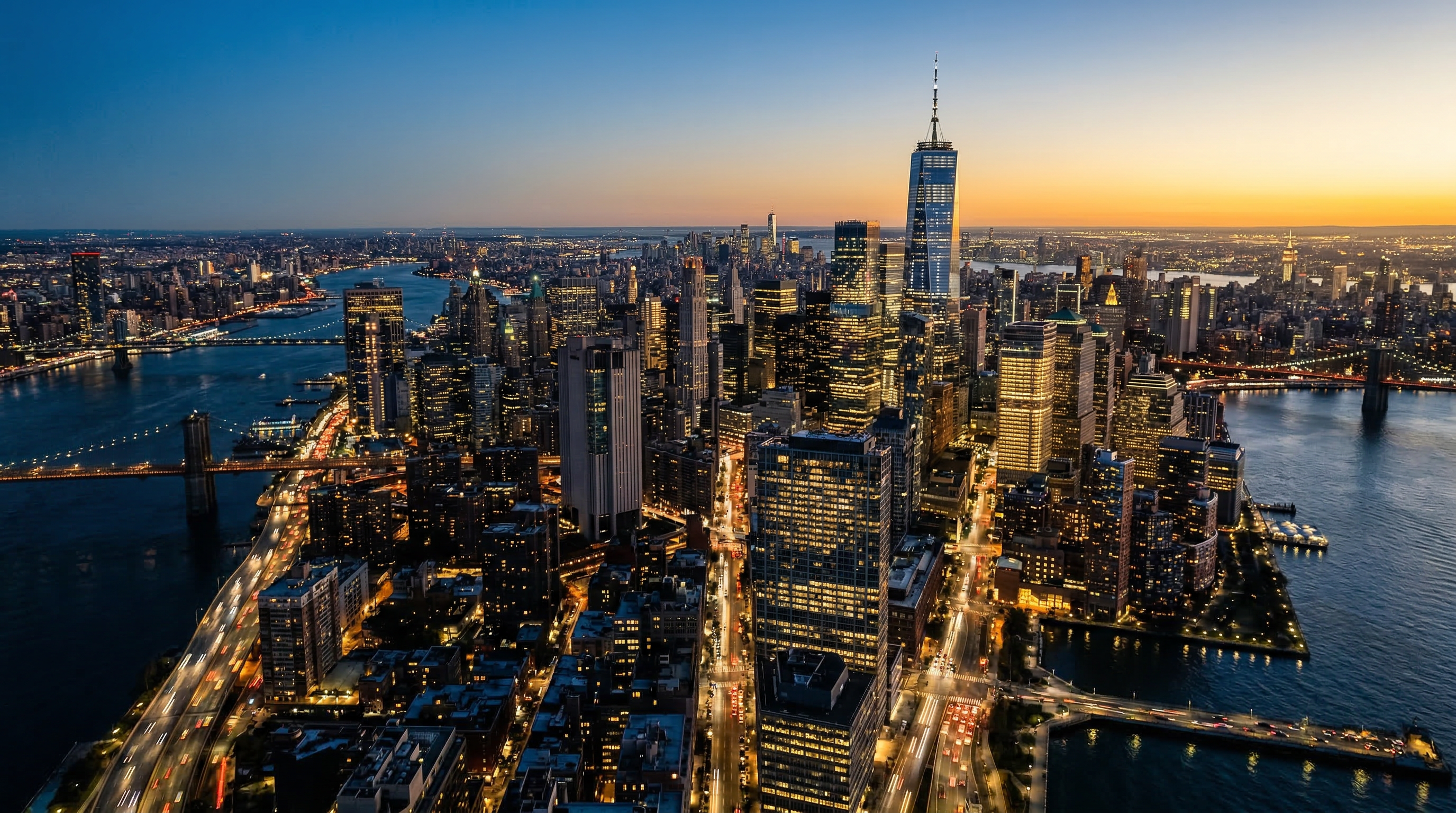 Aerial view of city at blue hour, warm lit skyscrapers